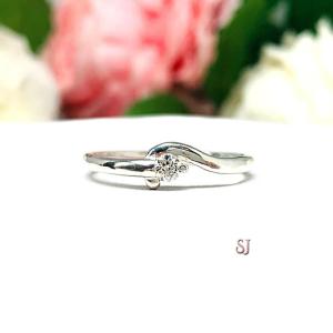 A silver round gemstone bypass ring with a thin band. The ring is set with a 3mm round moissanite. The modern setting design curves around the gemstone. The ring is facing toward the back and is set against a white background.