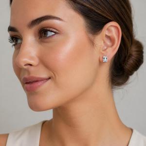 A close-up of a woman wearing an 8x6mm white sapphire emerald-cut stud earring. Model image for size and styling reference — not a photo of the actual earrings.