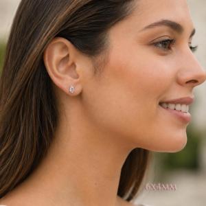 A woman wearing 6x4mm oval cz 6-prong stud earrings. Model image for size and styling reference — not a photo of the actual earrings.