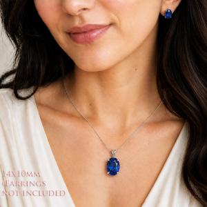 A woman wearing a 14x10mm lab blue sapphire oval sterling silver pendant necklace and smaller matching earrings. 'EARRINGS NOT INCLUDED' appears in pink text in the image. Model image for size and styling reference — not a photo of the actual necklace.