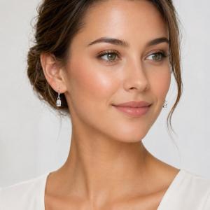 Woman wearing colorless oval cz dangle earrings. Model image for size and styling reference — not a photo of the actual earrings.