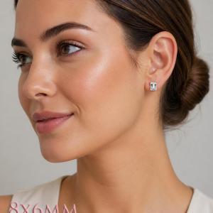 A woman wearing silver earrings set with 8x6mm emerald cut natural white topaz gemstones. Model image for size and styling reference — not a photo of the actual earrings.