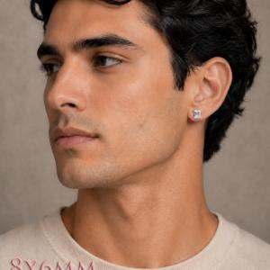 A man wearing silver earrings set with 8x6mm emerald cut natural white topaz gemstones. Model image for size and styling reference — not a photo of the actual earrings.