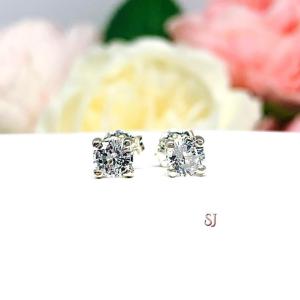 A pair of sterling silver 4-prong stud earrings set with round mixed brilliant lab white sapphires. Both earrings are facing forward to showcase the faceting and clear clarity of the stones.