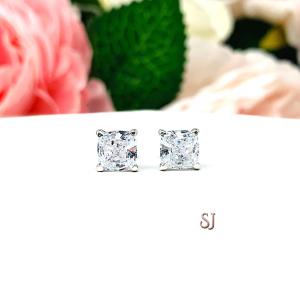 A pair of silver stud earrings with "crushed ice" cushion cut clear cubic zirconia stones. The basket style soft claw prong earrings are on a white surface. The earrings are facing forward to showcase the dazzling faceting of the crushed ice effect.