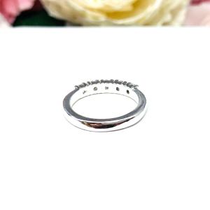 Sterling silver stackable 5-stone wedding band featuring 3mm round authentic moissanite stones in prong settings, displayed against a soft floral background.