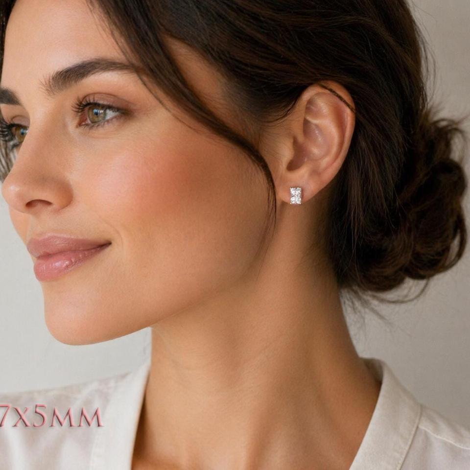 A woman wearing silver stud earrings with 7x5mm "crushed ice" rectangular radiant cut clear cubic zirconia stones. Model image for size and styling reference — not a photo of the actual earrings.
