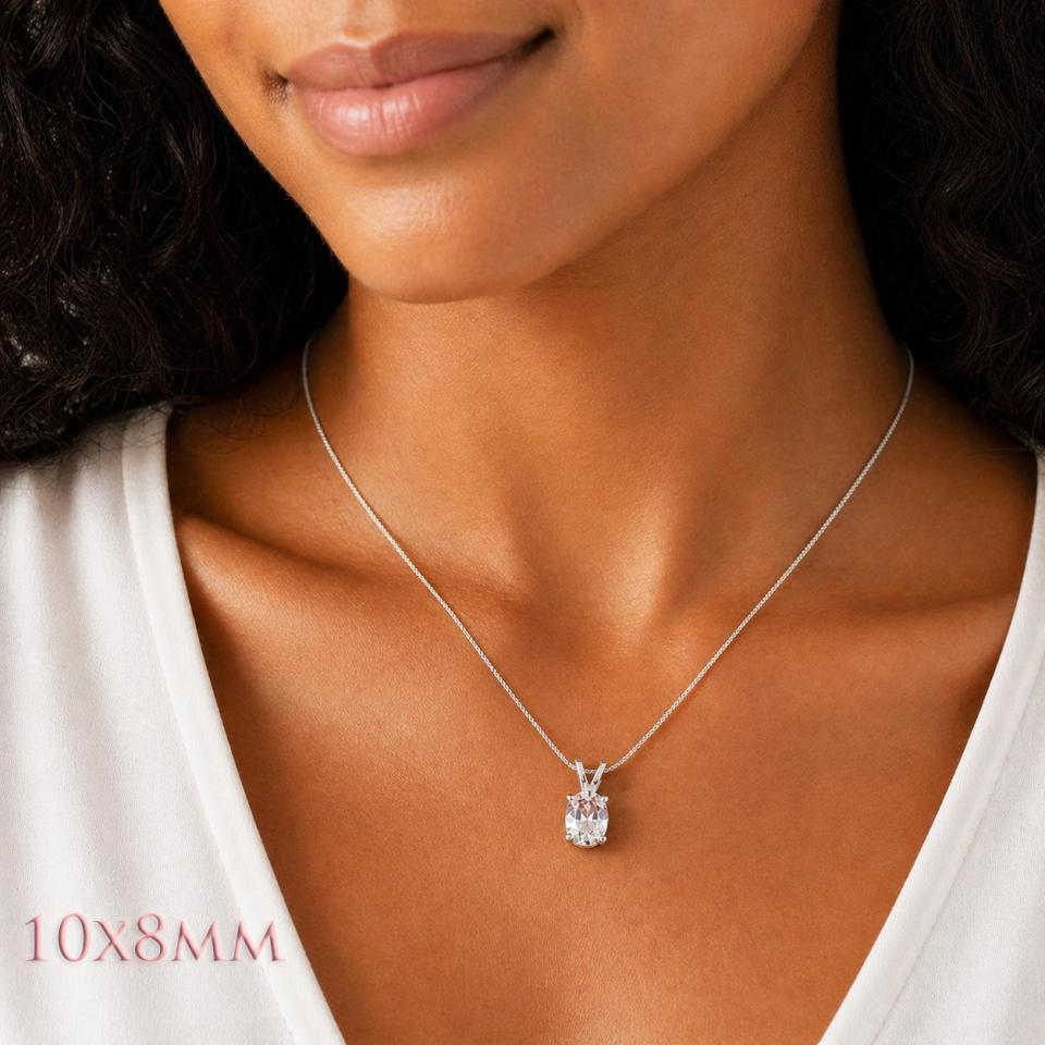 A woman wearing a 10x8mm oval lab white sapphire sterling silver pendant necklace. Model image for size and styling reference — not a photo of the actual necklace.
