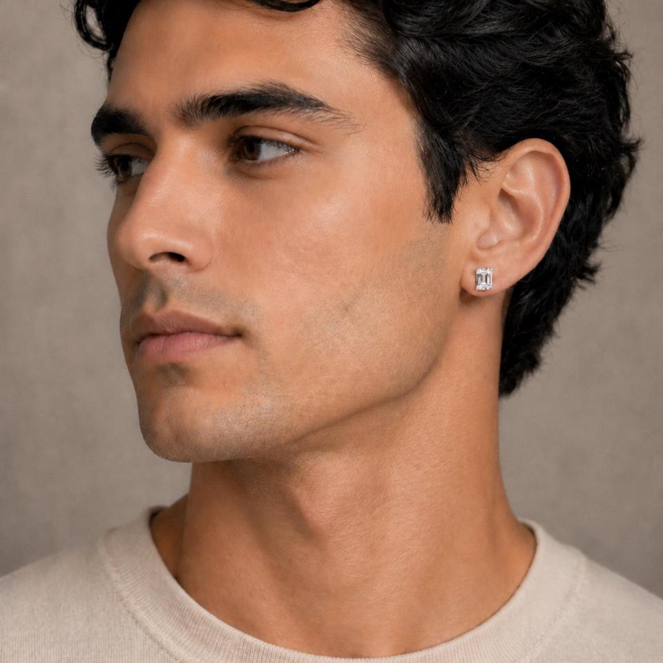 A close-up of a man wearing an 8x6mm white sapphire emerald-cut stud earring. Model image for size and styling reference — not a photo of the actual earrings.