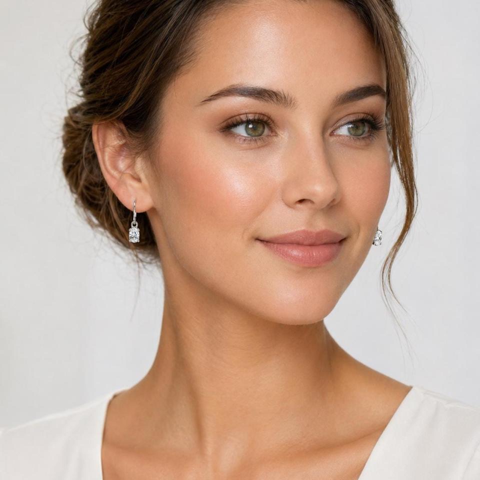 Woman wearing colorless oval cz dangle earrings. Model image for size and styling reference — not a photo of the actual earrings.