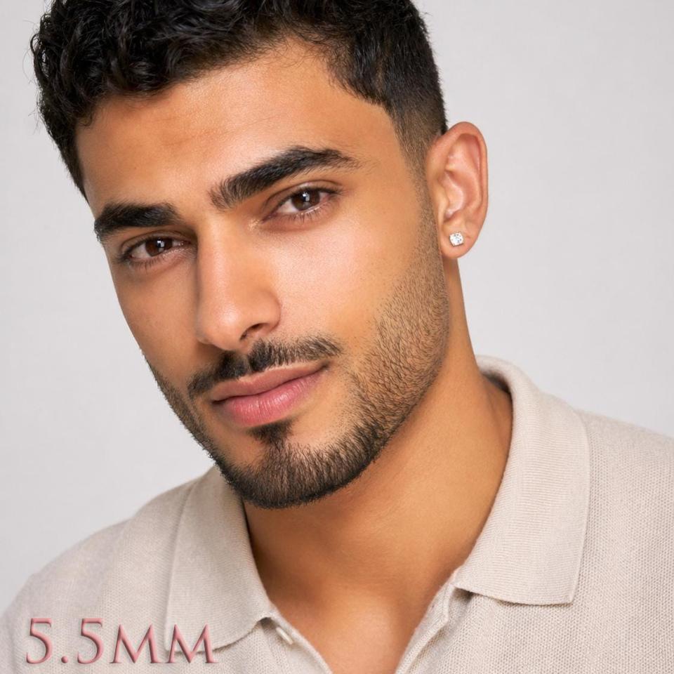A man wearing silver stud earrings set with 5.5mm cubic zirconia stones. Model image for size and styling reference — not a photo of the actual earrings.