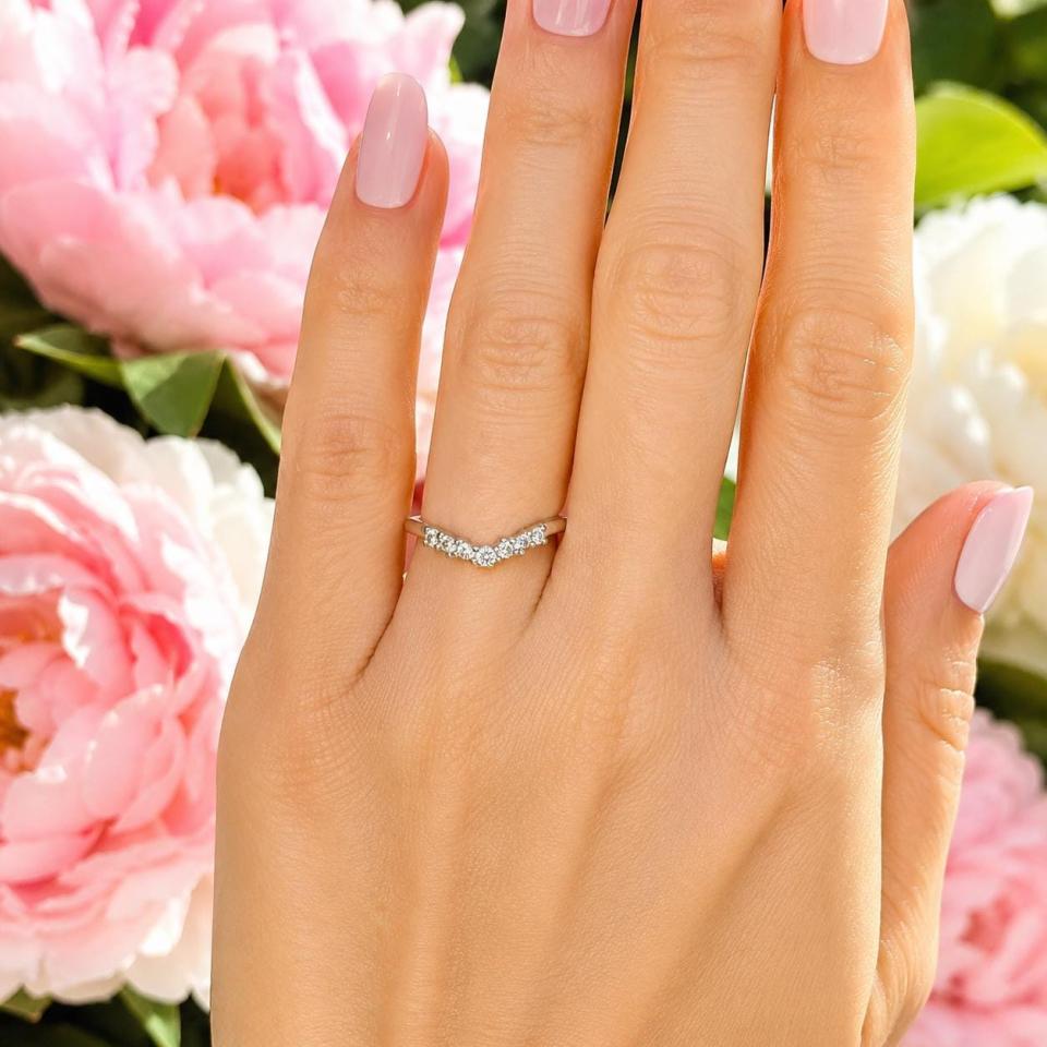 Sterling silver curved band set with 2mm round near colorless czs shown worn on a woman's hand. Model image for size and styling reference — not a photo of the actual ring