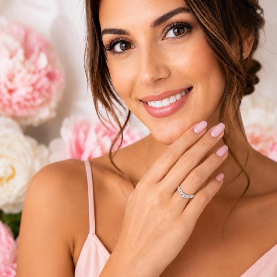 Woman wearing a curved sterling silver wedding band featuring five 3mm round moissanites.