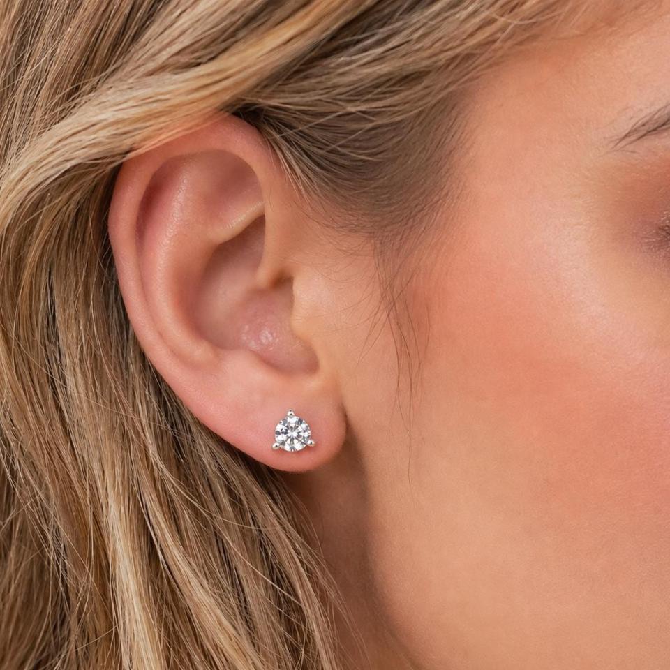 A woman wearing 6.5mm old european cut cz martini stud earrings. Model image for size and styling reference — not a photo of the actual earrings.