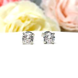 A pair of sterling silver 4-prong basket stud earrings set with round mixed brilliant lab white sapphires. Both earrings are facing forward to showcase the faceting and clear clarity of the stones.