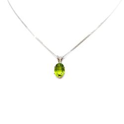 Bright neon green 9×7 mm oval apatite gemstone in a sterling silver six‑prong pendant, suspended from a delicate chain and displayed on a white background.