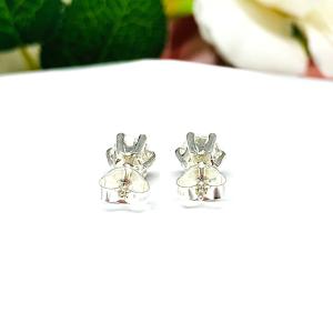 A pair of silver stud earrings set with round brilliant cut 'near colorless or 'G color' cubic zirconias.  The 6 prong earrings are on a white surface with both earrings facing toward the back to showcase the center post and butterfly friction clasps.