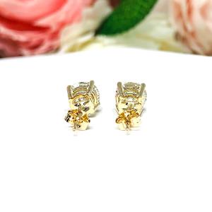 A pair of yellow gold stud earrings set with round brilliant cut 'near colorless or 'G color' cubic zirconias.  The four prong basket earrings are on a white surface with both earrings facing toward the back to showcase the center post and butterfly friction clasps.