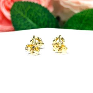 A pair of yellow gold martini stud earrings with round brilliant moissanites. The earrings are on a white background with both earrings facing toward the back to showcase the center post and butterfly friction clasp.