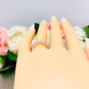 Mannequin hand with long white shimmery nails, displayed against a soft white-gray background with pink and white floral accents. The hand is wearing a sterling silver half-eternity, stackable 7-stone wedding band featuring 2mm round precision faceted cubic zirconia stones in prong settings.