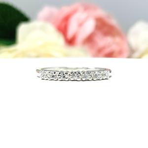 Sterling silver half-eternity, stackable 7-stone wedding band featuring 2mm round precision faceted cubic zirconia stones in prong settings, displayed against a soft floral background.
