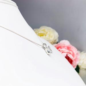 A sparkling princess cut cz in a double prong sterling silver setting, suspended from a delicate chain. The necklace is set against a white background.