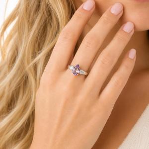 A woman wearing a stunning sterling silver ring with a pear‑cut Rose de France amethyst and round rainbow moonstones. Model image for size and styling reference — not a photo of the actual ring.
