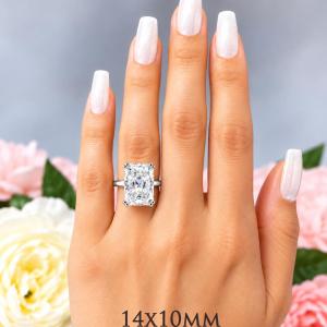 A woman's hand wearing a sterling silver double-prong 14x10mm radiant-cut cubic zirconia solitaire engagement ring. Model image for size and styling reference — not a photo of the actual ring.