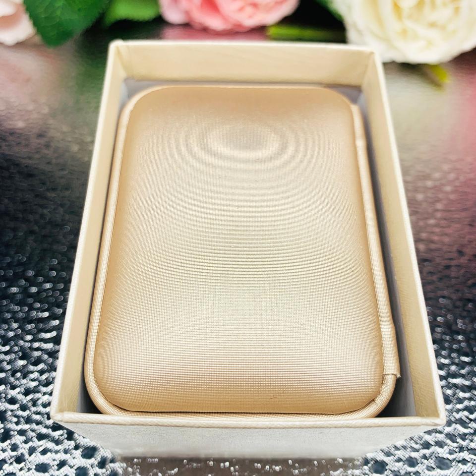 A shimmer champagne leatherette gift box with a soft ivory interior, designed to elegantly present necklaces with or without pendants. Nestled inside an ivory outer box and surrounded by delicate pink and white roses, this classy packaging adds a touch of luxury to any Shantastic Jewelry gift.