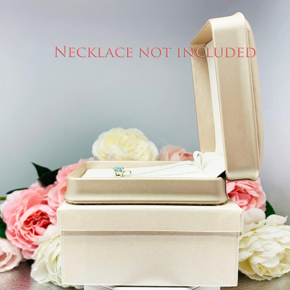 A shimmer champagne leatherette gift box with a soft ivory interior, designed to elegantly present necklaces with or without pendants. Nestled inside an ivory outer box and surrounded by delicate pink and white roses, this classy packaging adds a touch of luxury to any Shantastic Jewelry gift. Necklace shown is for display only and is not included.