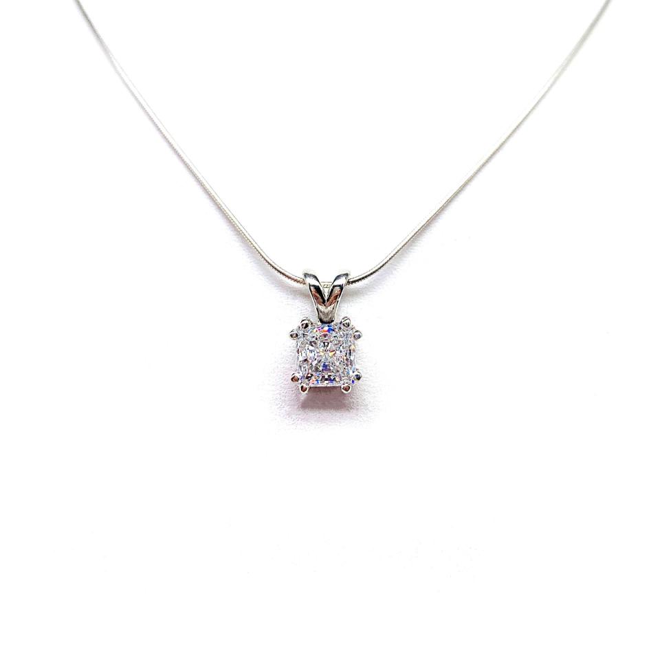 A sparkling princess cut cz in a double prong sterling silver setting, suspended from a delicate chain. The necklace is set against a white background.