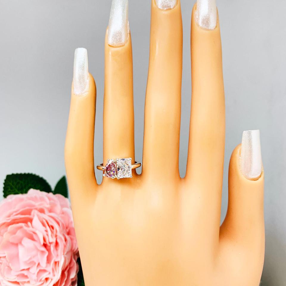 8x5mm morganite pink color pear CZ and 8x6mm colorless radiant-cut cz toi et moi ring in sterling silver shown worn on a mannequin hand.